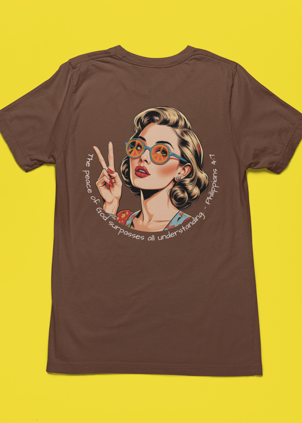 Christian t-shirt with a graphic of a 70s inspired woman with glasses and a peace sign on a yellow background. White Christian graphic tee with retro 70s inspired woman holding up a peace sign and wearing peace sign glasses. Inspired by the scripture Philippians 4:7. 