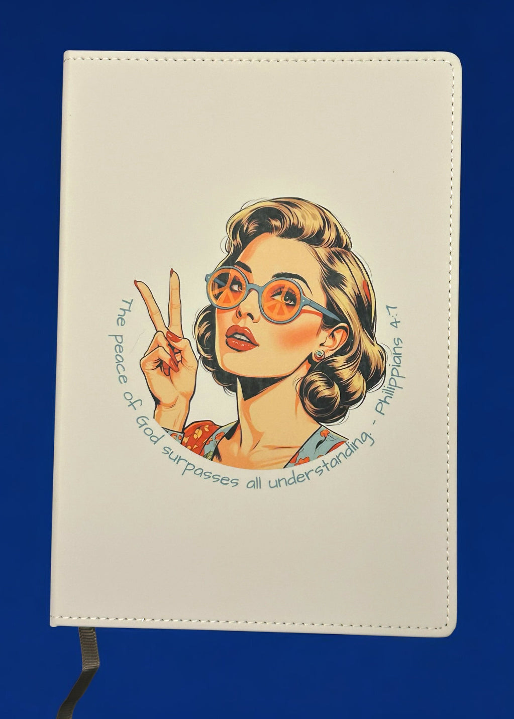 Notebook with a design of a woman with glasses and a peace sign on a blue background