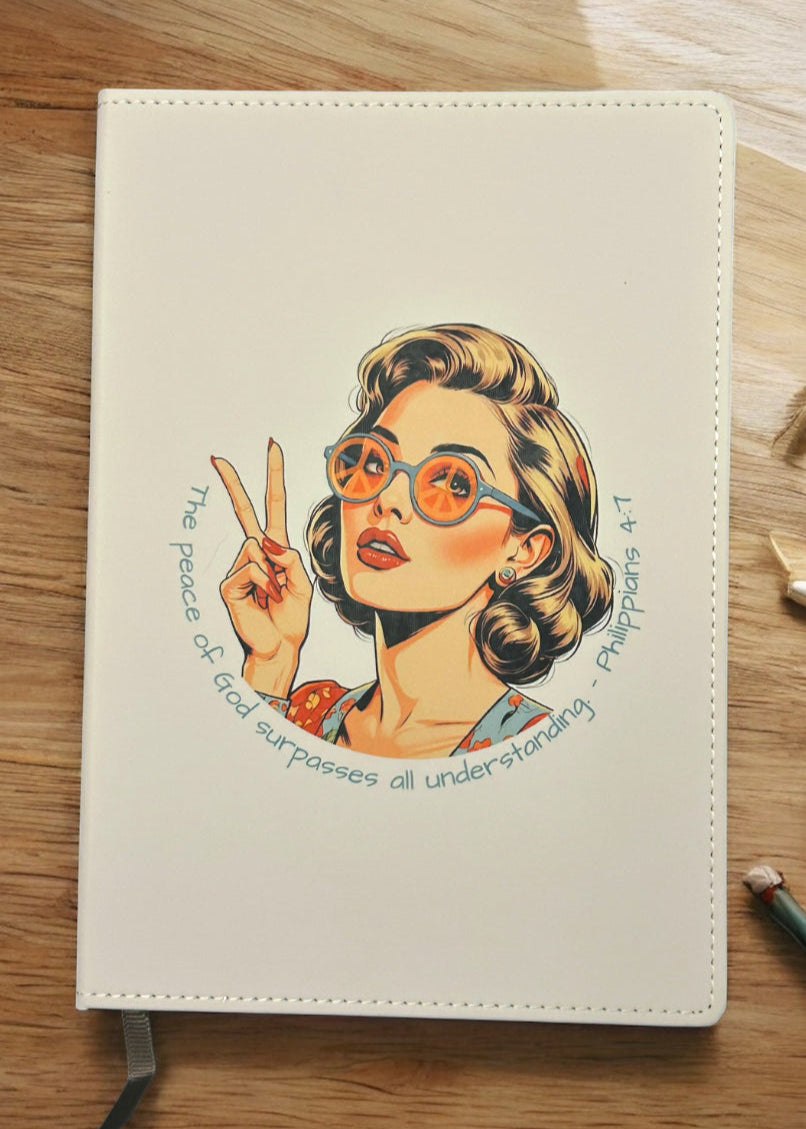 Notebook with a colorful illustration of a woman on a wooden surface