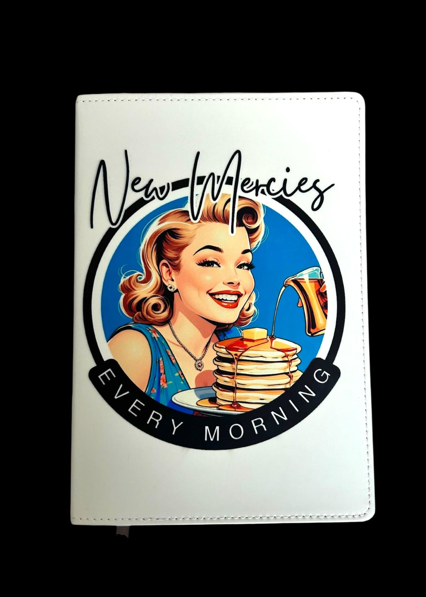 Product with a graphic of a woman with pancakes and the text 'New Mercies Every Morning' on a white background.