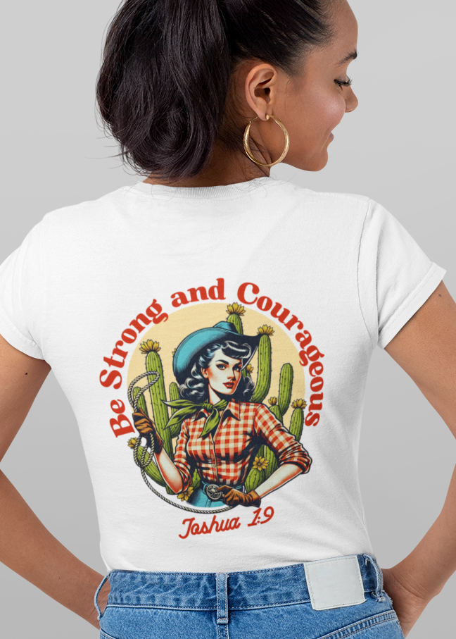 A woman modeling a white short-sleeve graphic T-shirt shown from both front and back against a light gray studio background. The front has a small multicolor chest graphic, and the back has a large graphic with the text 'Be Strong and Courageous' and 'Tula 1915'.