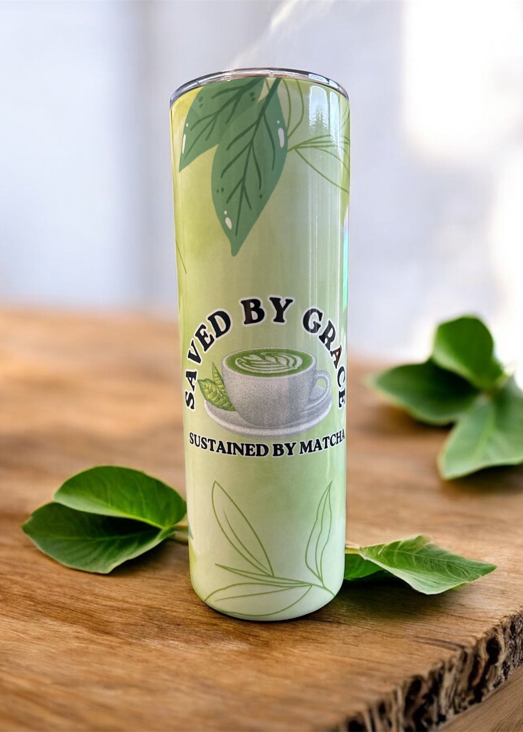 20 oz green tumbler with matcha latte in front. Saved by Grace sustained by Matcha