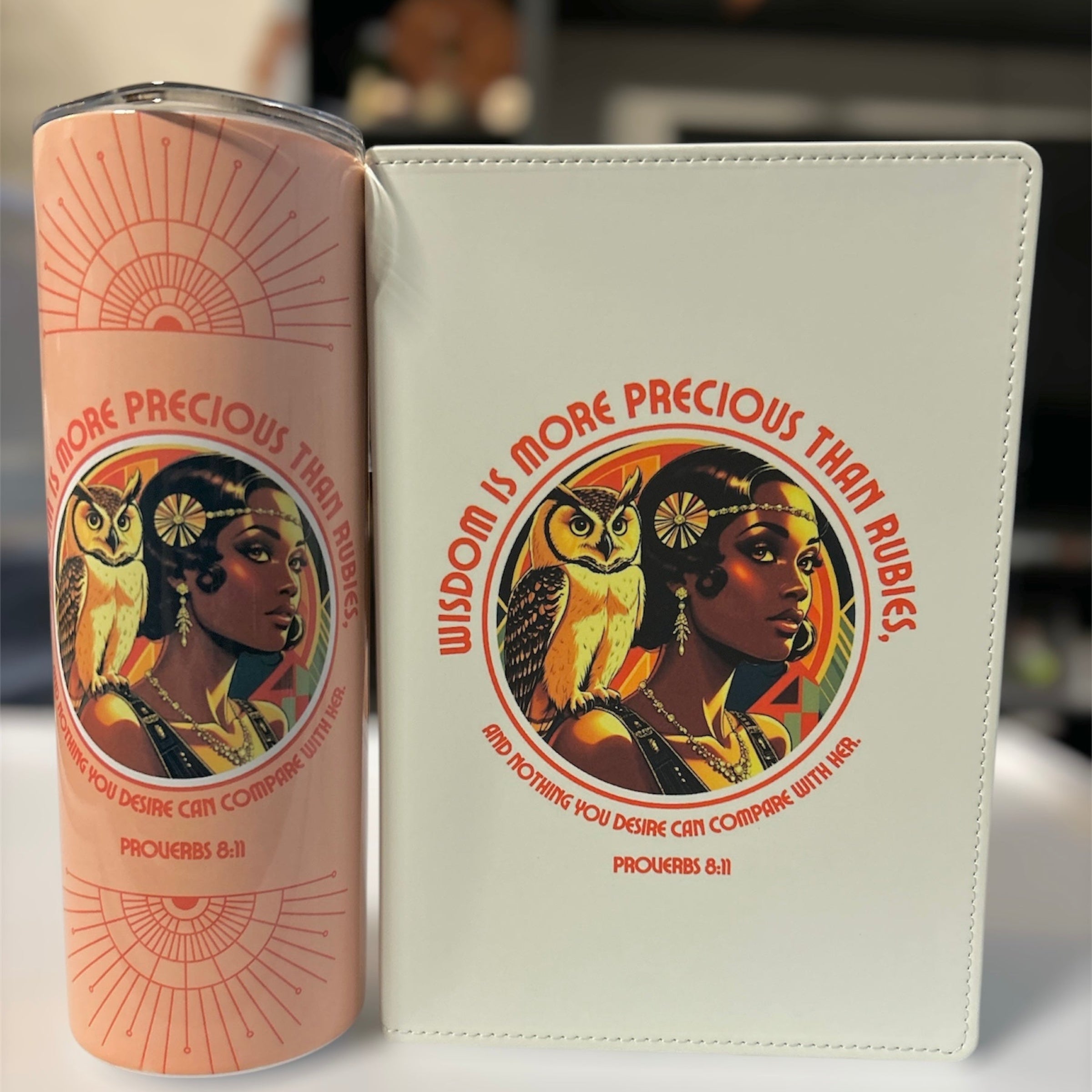Pink cylindrical container and white book with illustrated cover featuring a woman and owl, Proverbs 3:15 text.
