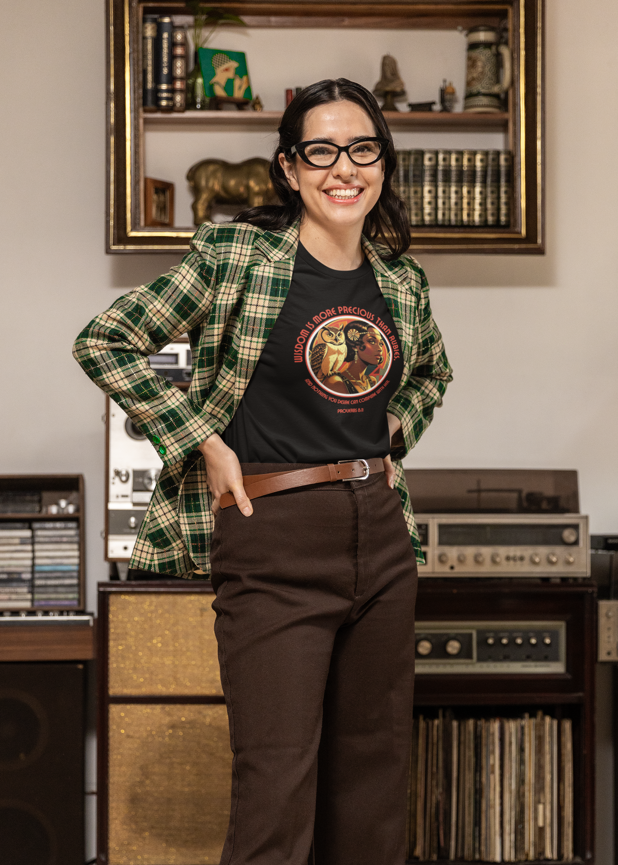Person wearing a plaid shirt and black t-shirt with a graphic design, standing in a room with vintage equipment.