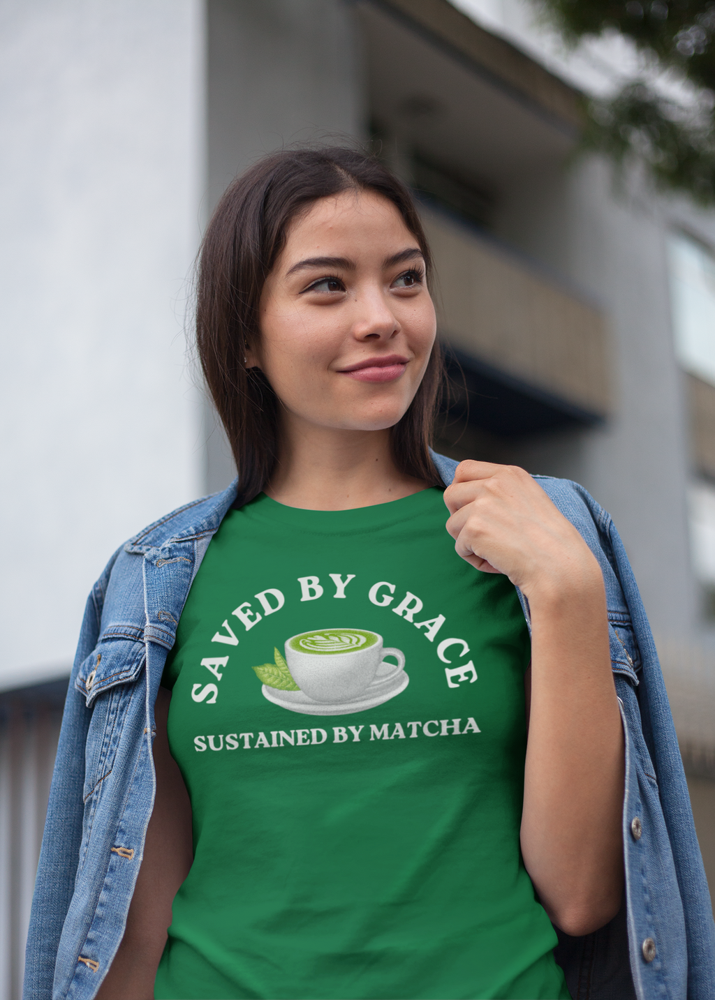 Person wearing a green t-shirt with 'Saved by Grace, Sustained by Matcha' design outdoors.